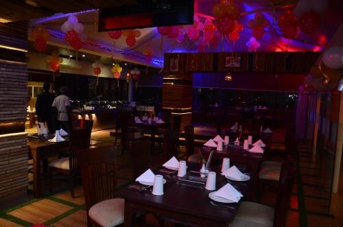 a dining room with tables and chairs with paper napkins at Hotel Ramaya in Gwalior