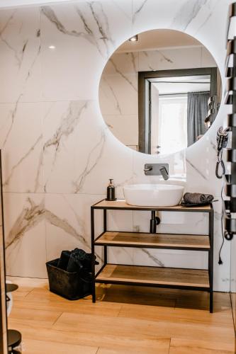 a bathroom with a sink and a mirror at Apartamenty Larice - balia lub sauna sesja gratis ten weekend, morsowanie w basenie in Świeradów-Zdrój