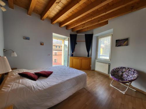 a bedroom with a large bed and a chair at Lilla Apartment Residenza Silvana in Verbania