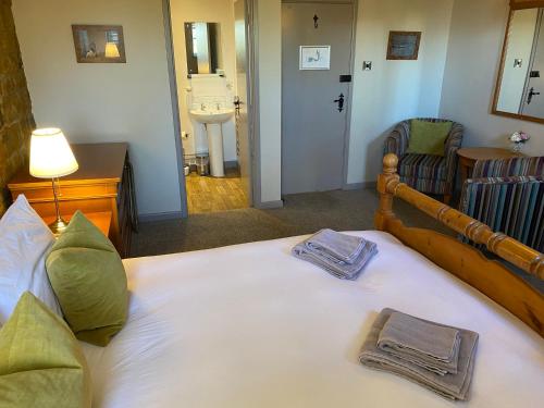 a bedroom with a large bed with two towels on it at The Hollybush Inn and B&B in Priors Marston