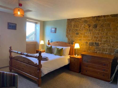 a bedroom with a bed and a brick wall at The Hollybush Inn and B&B in Priors Marston