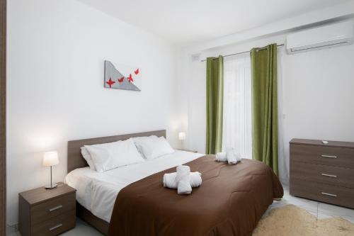 um quarto com uma cama com dois ursinhos de peluche em Sea View Apartment 2 bedrooms 2 bathrooms, 2 minutes away from the sea em St Julian's