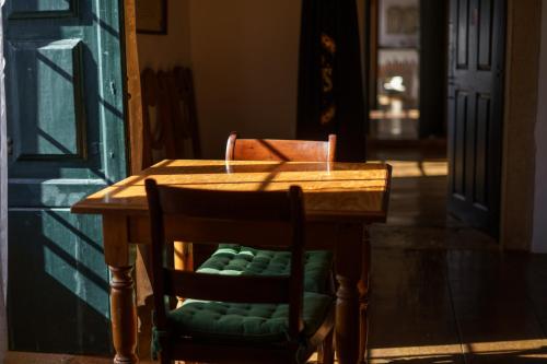 a wooden table with two chairs and a table with a door at Quinta de Santa Barbara by Heavens Sleepy in Constância