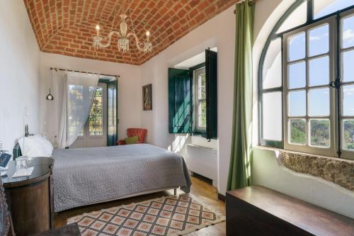 a bedroom with a bed in a room with windows at Quinta de Santa Barbara by Heavens Sleepy in Constância