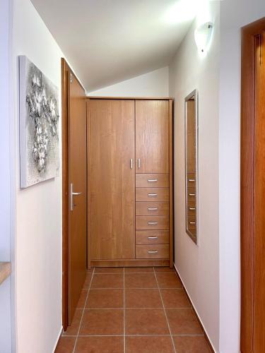 a hallway with wooden cabinets and a tiled floor at Apartment Lady Daniela mit Meerblick in Lovran in Lovran