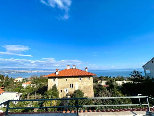 an old building with a red roof on a hill at Apartment Lady Daniela mit Meerblick in Lovran in Lovran