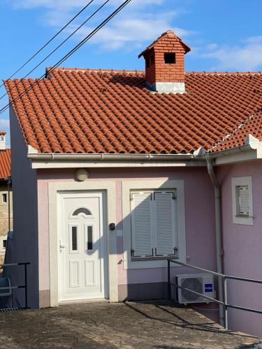 a small house with a red tile roof at Apartment Lady Daniela mit Meerblick in Lovran in Lovran