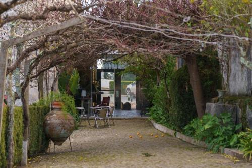 an archway with a table and a vase in a garden at Quinta de Santa Barbara by Heavens Sleepy in Constância