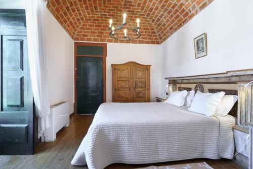 a bedroom with a large bed and a chandelier at Quinta de Santa Barbara by Heavens Sleepy in Constância