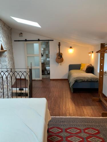 - une chambre avec un lit et une guitare sur le mur dans l'établissement Charming typical stone house with modern amenities, à Chauzon