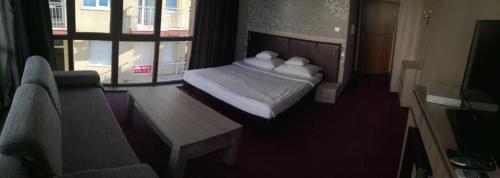 a bedroom with a bed and a table and a window at euroHOTEL Primorsko in Primorsko