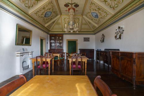 a dining room with tables and chairs and a chandelier at Quinta de Santa Barbara by Heavens Sleepy in Constância
