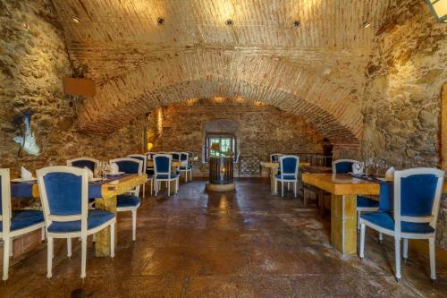 a dining room with tables and chairs in a stone wall at Quinta de Santa Barbara by Heavens Sleepy in Constância