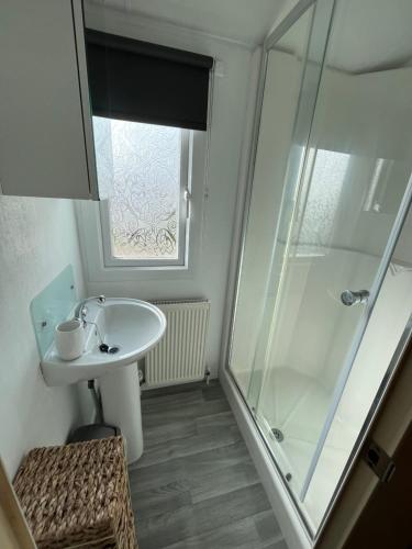 a bathroom with a sink and a glass shower at Grouse 54, Scratby - California Cliffs, Parkdean, sleeps 6, pet friendly, bed linen, towels and Wi-Fi included in Scratby