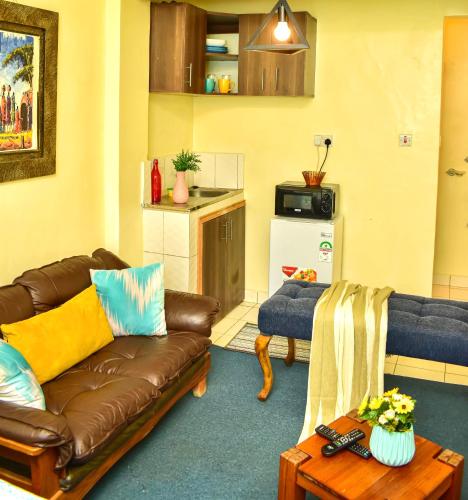 a living room with a couch and a table at Classic Studio Milimani - Wi-Fi and Parking in Kisumu