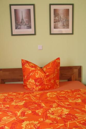 an orange bed with two orange pillows on top of it at Gasthaus Forelle in Thale