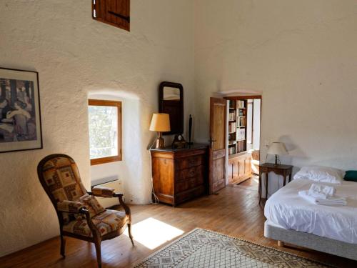 une chambre avec un lit, une chaise et un miroir dans l'établissement Charming House in Ardèche near Les Vans, à Saint-Genest-de-Bauzon
