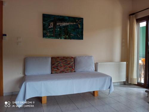 a bed in the corner of a room at Orfeas -Vacation Home in Paralia Panteleimonos
