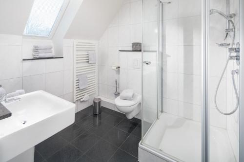 een witte badkamer met een douche en een toilet bij Villa Seegatt 7 in Norderney