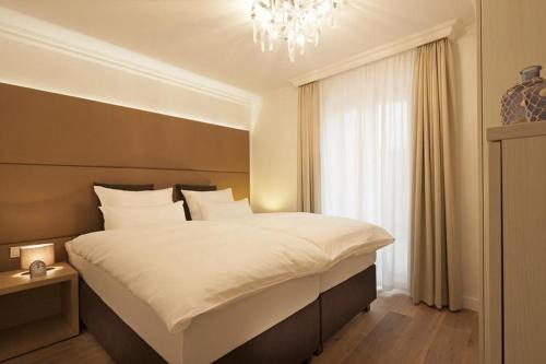 ein Schlafzimmer mit einem großen Bett und einem Kronleuchter in der Unterkunft Villa Vie 1 in Norderney