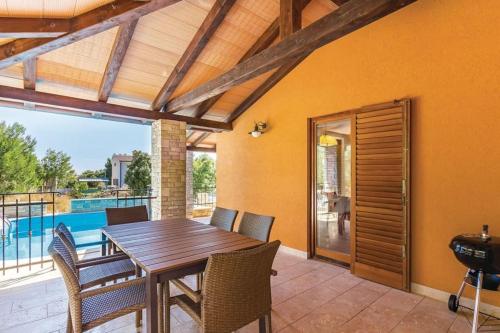 a dining room with a table and chairs and a pool at Villa Family in Medulin