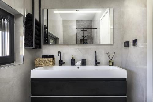 a bathroom with a white sink and a mirror at Villa M Premantura in Premantura