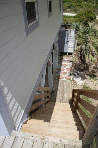 a stairway leading up to a house with a porch at Serenity Now in Holden Beach