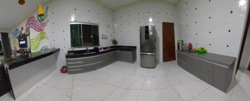 a large kitchen with a refrigerator in a room at Casa com Piscina e 3 Quartos Climatizados 8km do Centro in Palmas
