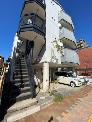 熊本的住宿－Kumamoto - Apartment - Vacation STAY 22588v，停在带阳台的大楼外的白色汽车