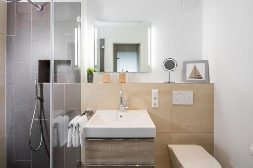 een badkamer met een wastafel en een spiegel bij Sommerdeich4you in Norderney