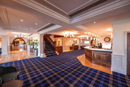a large room with a staircase and a living room at Carden Park Hotel, Golf Resort and Spa in Tilston