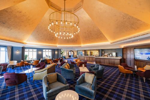 a hotel lobby with chairs and a waiting room at Carden Park Hotel, Golf Resort and Spa in Tilston