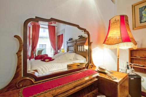 a bedroom with a bed with a large mirror at B&B Il Marchese Del Grillo in Sulmona
