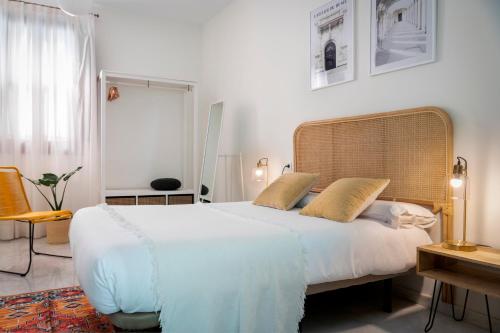 a bedroom with a large white bed with two pillows at MonKeys Apartments Alameda House in Seville