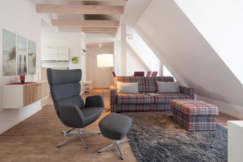 een woonkamer met 2 stoelen en een bank bij Villa Brunnenhof 06 in Norderney