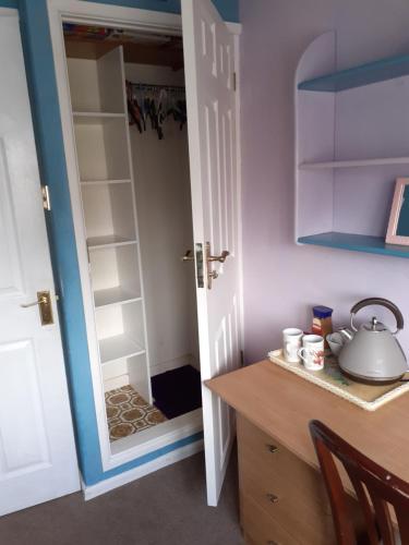 a kitchen with a door open to a closet at Home from home, single room with virgin channels, Wifi & free parking in Poole