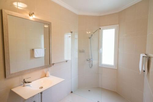 a bathroom with a shower and a sink and a mirror at Luxury villa with private heated pool, garden and views of the sea and mountains. in Arco da Calheta