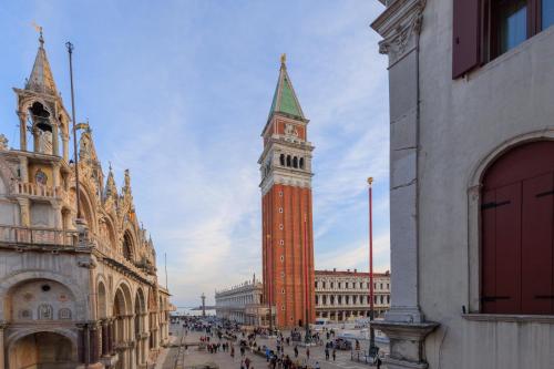 a tall clock tower in a city with a crowd of people at 312 Piazza San Marco in Venice