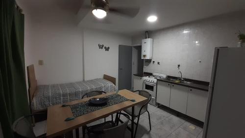 a small kitchen with a table and a bed at DEPARTAMENTO LAPRIDA in La Banda