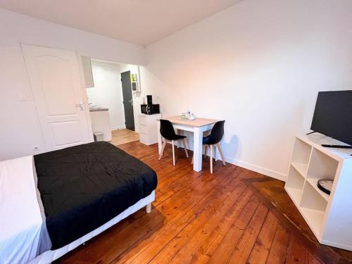 1 dormitorio con 1 cama y 1 mesa con sillas en Key-s Meaux/Maciet4/centre/Disney, en Meaux