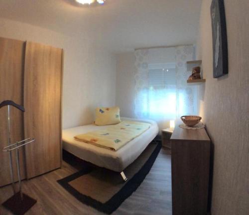 a small bedroom with a bed and a wooden cabinet at Ferienwohnung Renate Pfaller in Riedenburg