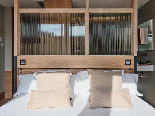 a bedroom with a large white bed with white pillows at Qgat Restaurant Events & Hotel in Sant Cugat del Vallès