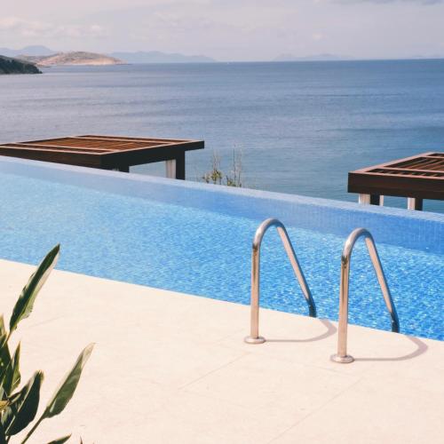 a swimming pool with a view of the ocean at Allium Bodrum Resort & Spa in Yalıkavak