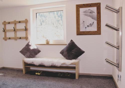 a room with a bench with two pillows on it at Apartment VIERSTERNE in Neustift im Stubaital