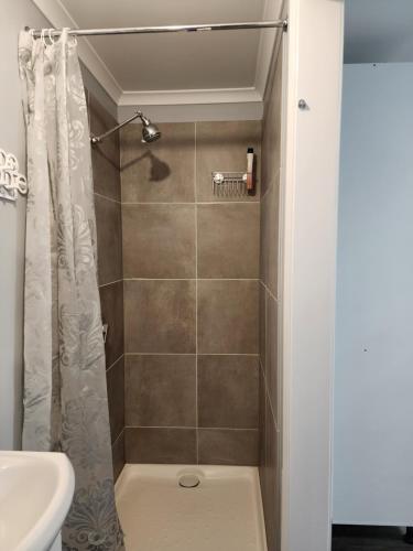 a bathroom with a shower with a toilet and a sink at Shepparton Central Guest Suite in Shepparton