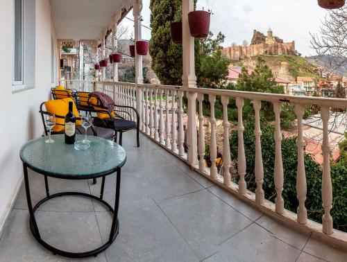 uma varanda com cadeiras e uma mesa com vista para um castelo em Gvino Minda em Tbilisi