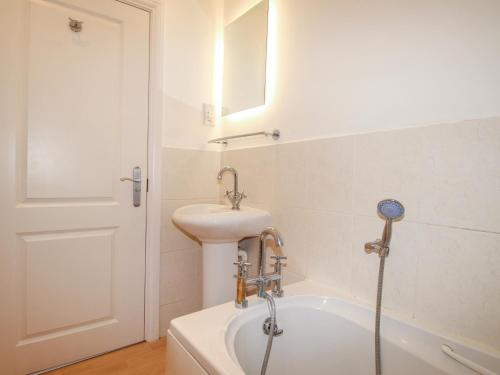 a bathroom with a sink and a bath tub at Nine Barrow View in Swanage