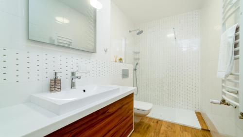 a white bathroom with a sink and a shower at Triventi Mountain Residence, Sun & Snow in Karpacz