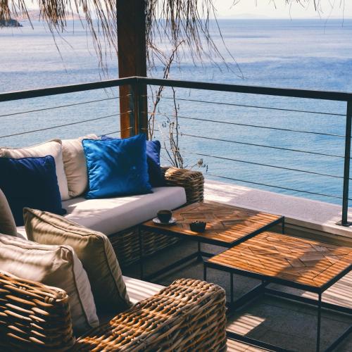 a balcony with chairs and a couch and a table at Allium Bodrum Resort & Spa in Yalıkavak