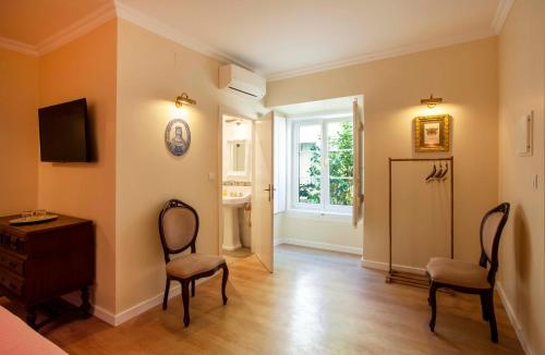 a room with two chairs and a refrigerator and a window at Palácio de Sintra Boutique House in Sintra